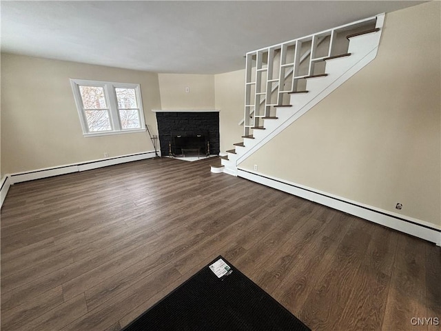 unfurnished living room featuring a baseboard radiator, a fireplace, dark wood finished floors, and stairs