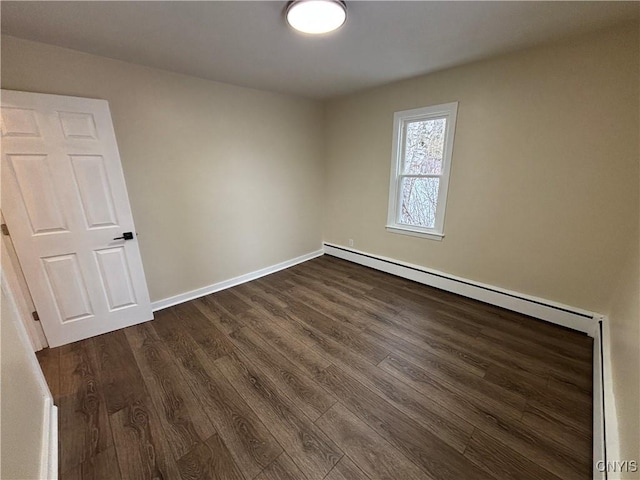 spare room featuring dark wood-type flooring and baseboards