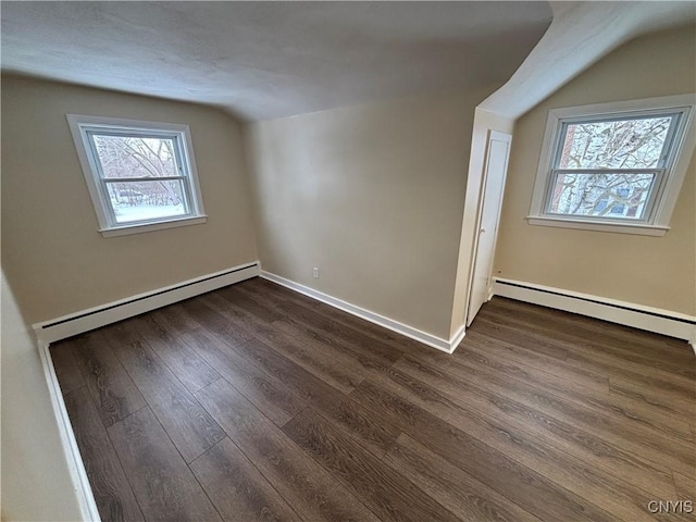 bonus room featuring dark wood-type flooring, baseboards, vaulted ceiling, and baseboard heating