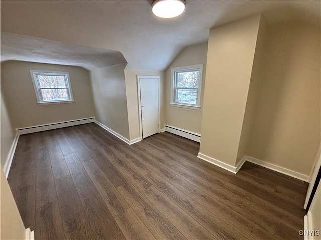 bonus room featuring a baseboard heating unit, vaulted ceiling, dark wood finished floors, and baseboards