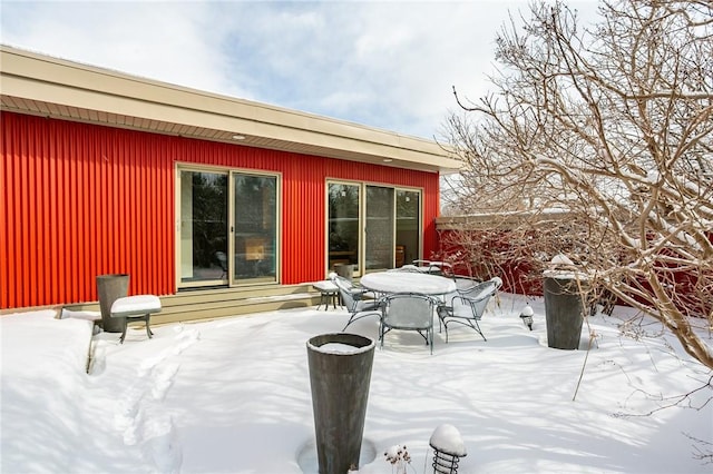 snow covered patio with outdoor dining space