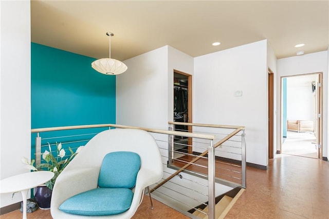 interior space featuring recessed lighting, baseboards, and an upstairs landing