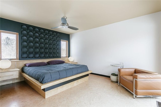 bedroom with ceiling fan and baseboards