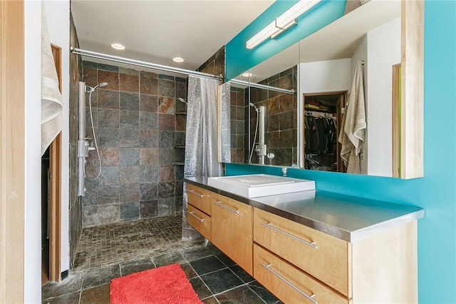 full bath featuring recessed lighting, a walk in closet, tiled shower, and vanity