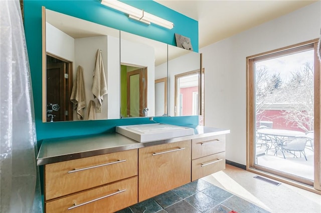 bathroom featuring baseboards, visible vents, and vanity