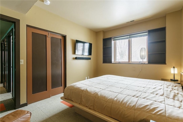 carpeted bedroom featuring a closet and visible vents