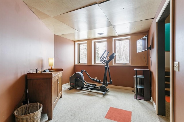 exercise area with visible vents, baseboards, and light colored carpet