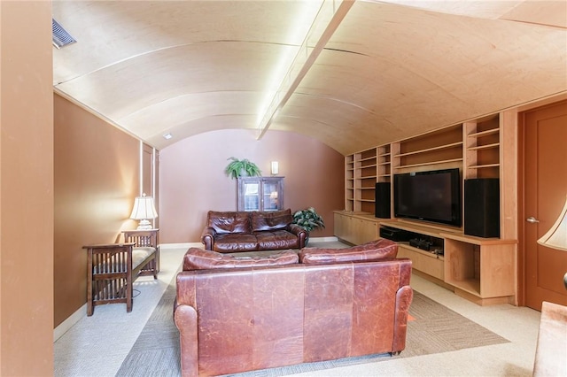 carpeted living room with lofted ceiling, visible vents, built in shelves, and baseboards