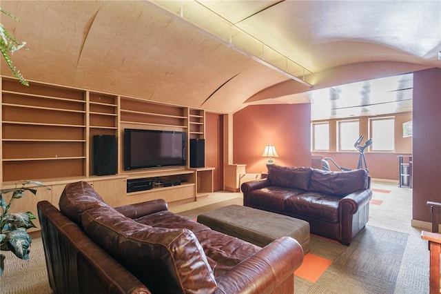 living room with built in shelves, lofted ceiling, and carpet flooring