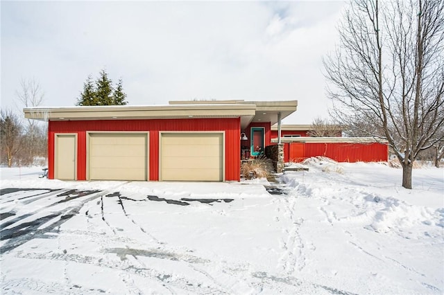 snow covered garage featuring a detached garage