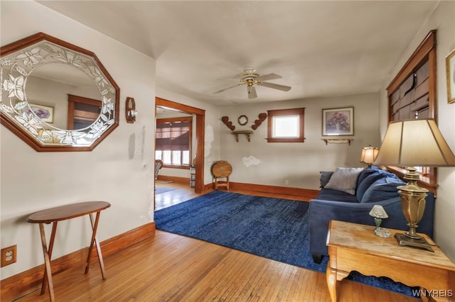 sitting room featuring baseboards, plenty of natural light, a ceiling fan, and wood finished floors