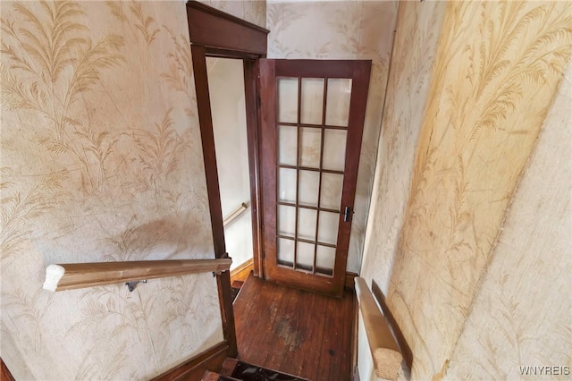 interior space featuring wood finished floors and wallpapered walls