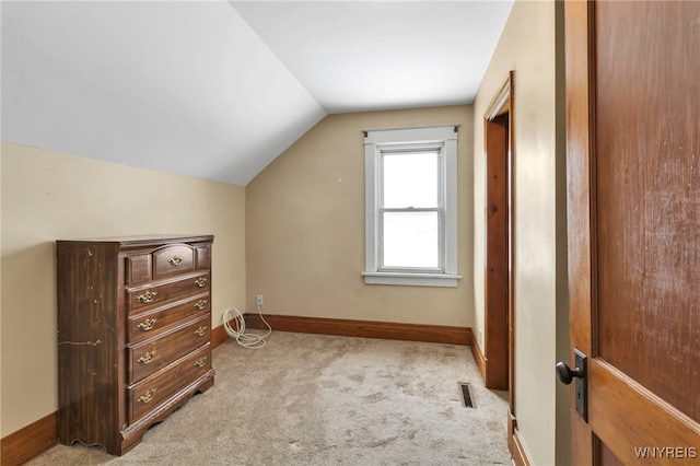 additional living space with lofted ceiling, light carpet, visible vents, and baseboards