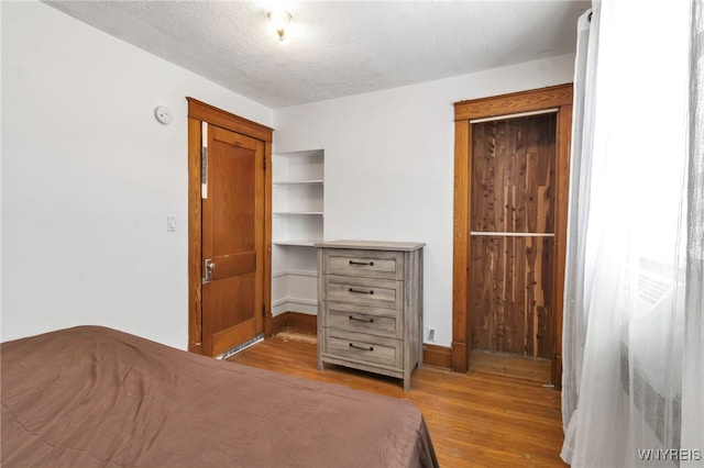 bedroom with a textured ceiling and light wood-type flooring