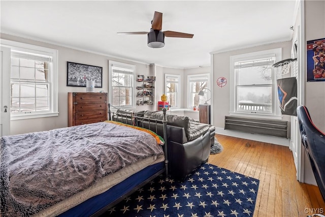 bedroom with ceiling fan, ornamental molding, and wood finished floors