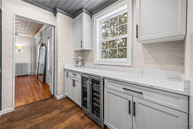 kitchen featuring wine cooler, radiator, dark wood-type flooring, white cabinets, and light stone countertops