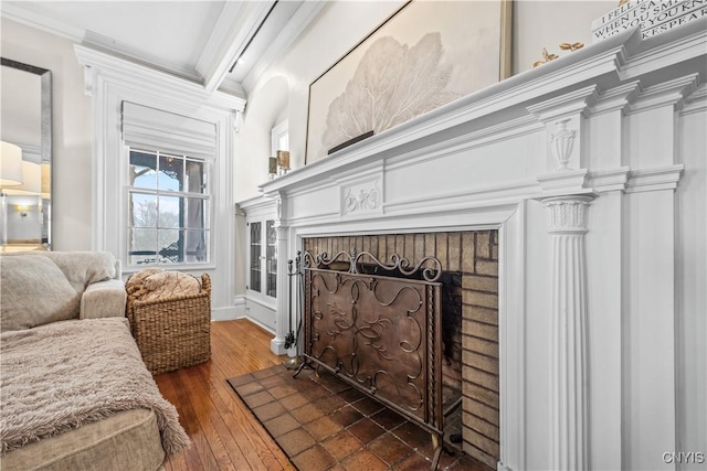 interior space featuring dark wood-type flooring, a brick fireplace, and crown molding