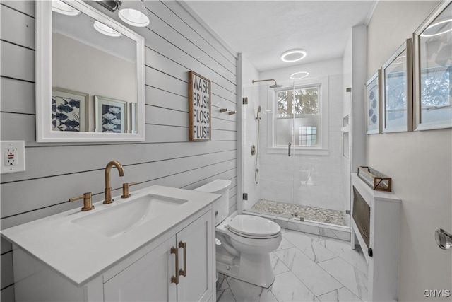 bathroom featuring toilet, marble finish floor, a shower stall, and vanity