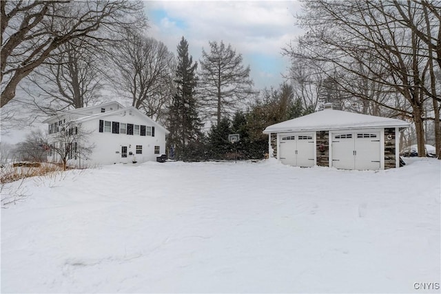 yard layered in snow with a detached garage