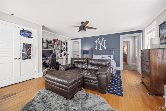 bedroom featuring baseboards, crown molding, a ceiling fan, and wood finished floors