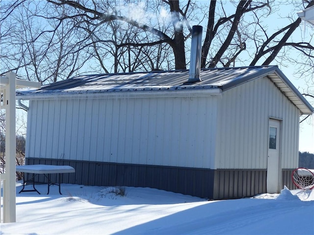 view of snow covered exterior with metal roof