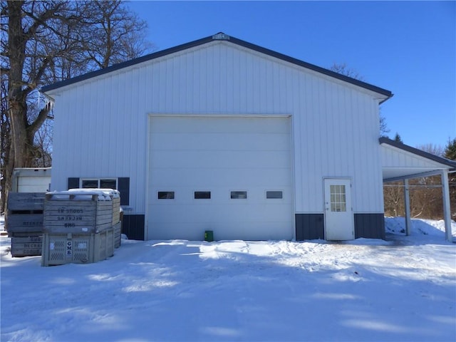 snow covered garage featuring a garage