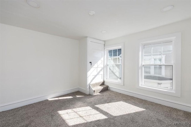 carpeted empty room featuring baseboards