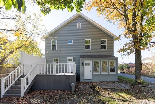 back of house with fence, a deck, and stairs