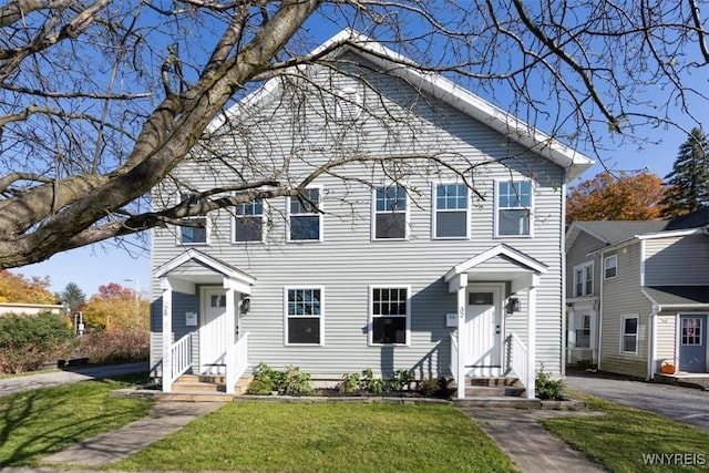 view of front of property with entry steps and a front lawn