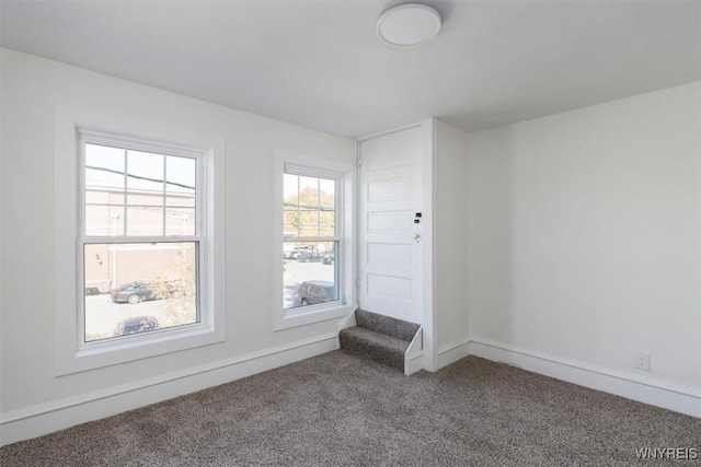 carpeted empty room featuring baseboards