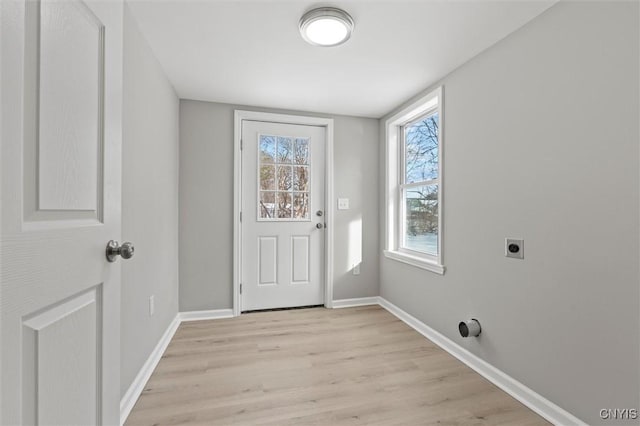 doorway featuring light wood-style flooring and baseboards