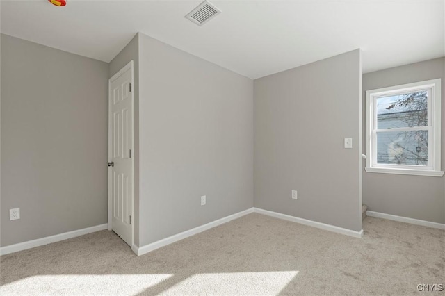 unfurnished bedroom featuring baseboards, visible vents, and light colored carpet