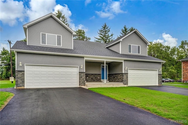 traditional-style home featuring a garage, stone siding, aphalt driveway, and a front lawn