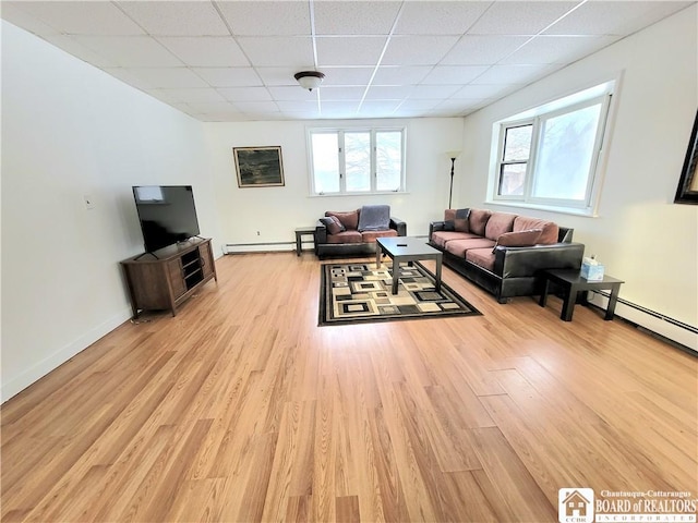 living room featuring a paneled ceiling, light wood finished floors, a baseboard radiator, and baseboards