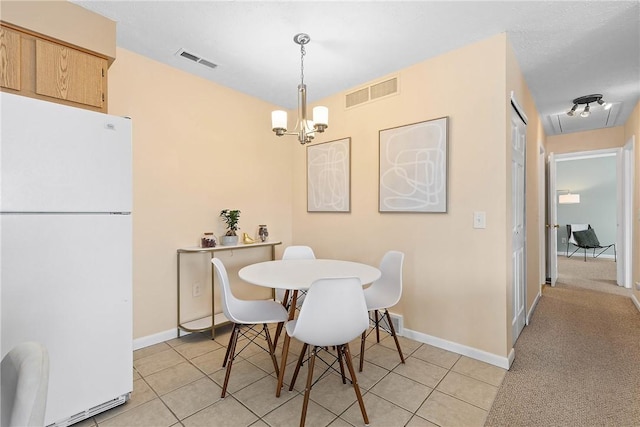 dining room featuring a chandelier, light tile patterned flooring, and visible vents