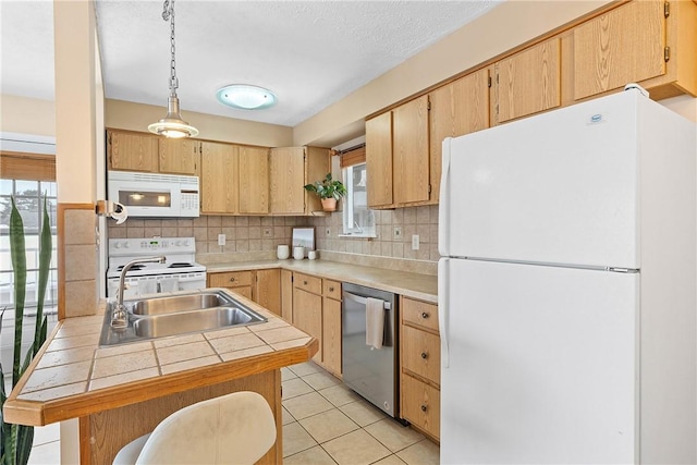 kitchen with light brown cabinets, white appliances, a sink, tasteful backsplash, and pendant lighting