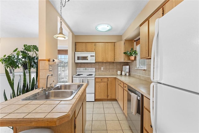 kitchen featuring white appliances, light tile patterned floors, decorative light fixtures, light countertops, and a sink