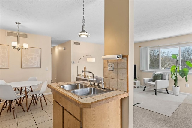 kitchen with visible vents, a sink, and a textured ceiling