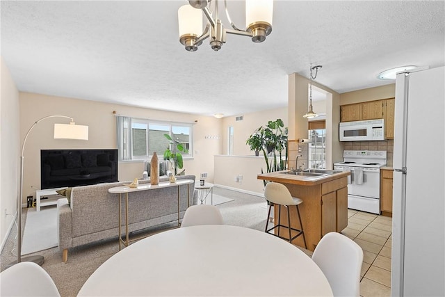 dining space with light tile patterned floors, a notable chandelier, baseboards, and a textured ceiling