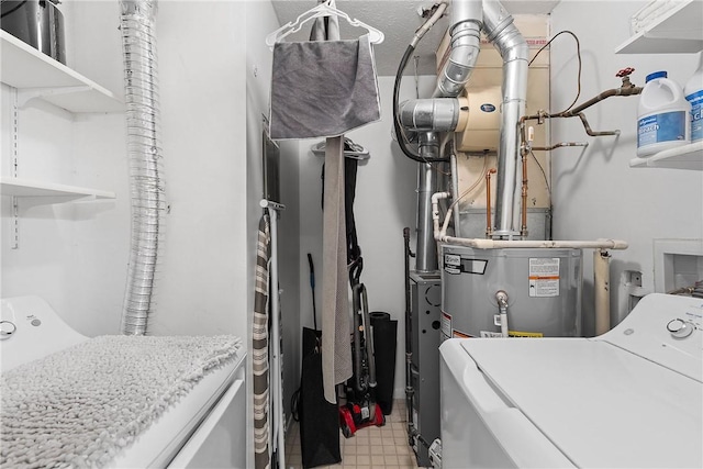 washroom with laundry area, water heater, washing machine and clothes dryer, and light floors