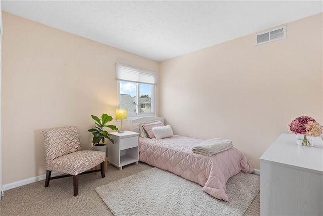 bedroom featuring baseboards, visible vents, and light colored carpet