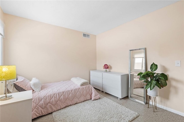 bedroom featuring baseboards, visible vents, and light colored carpet