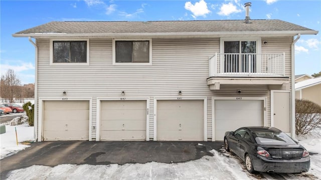 view of front of property featuring a garage and a balcony