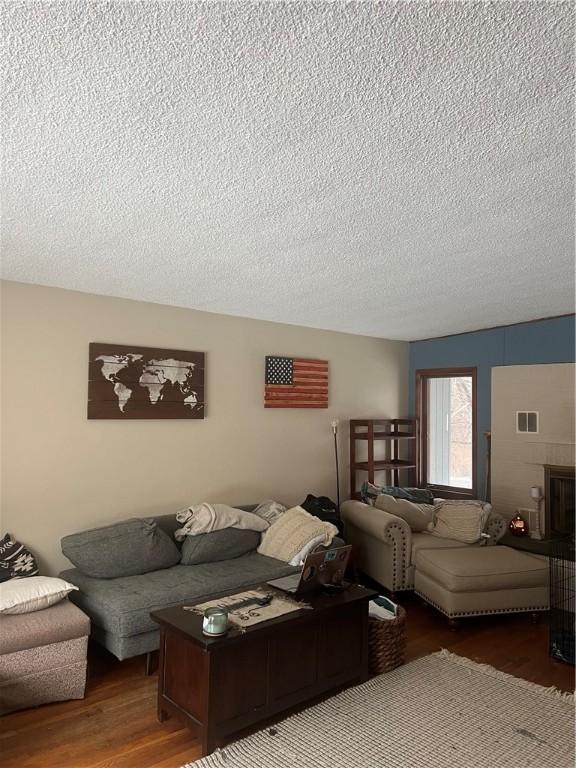 living area with a textured ceiling and wood finished floors