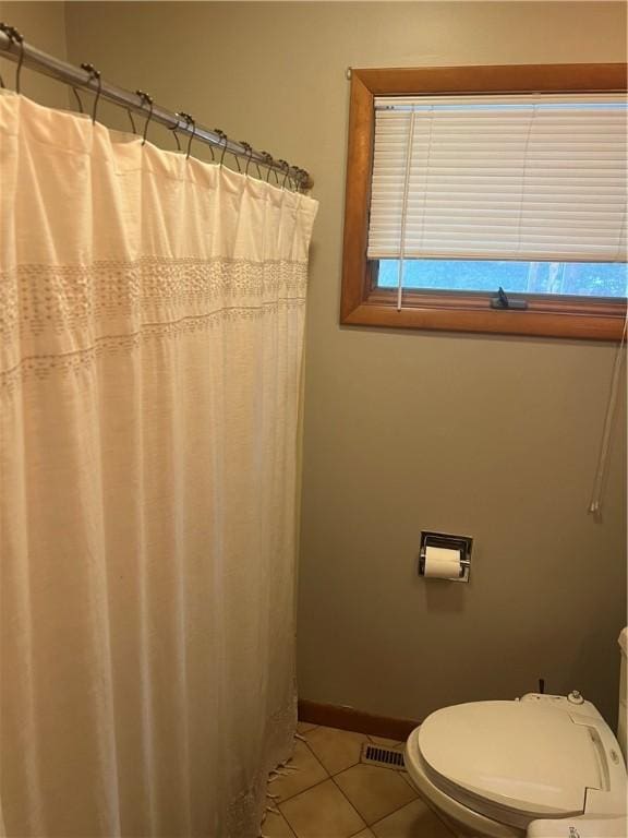 bathroom featuring visible vents, toilet, curtained shower, tile patterned flooring, and baseboards