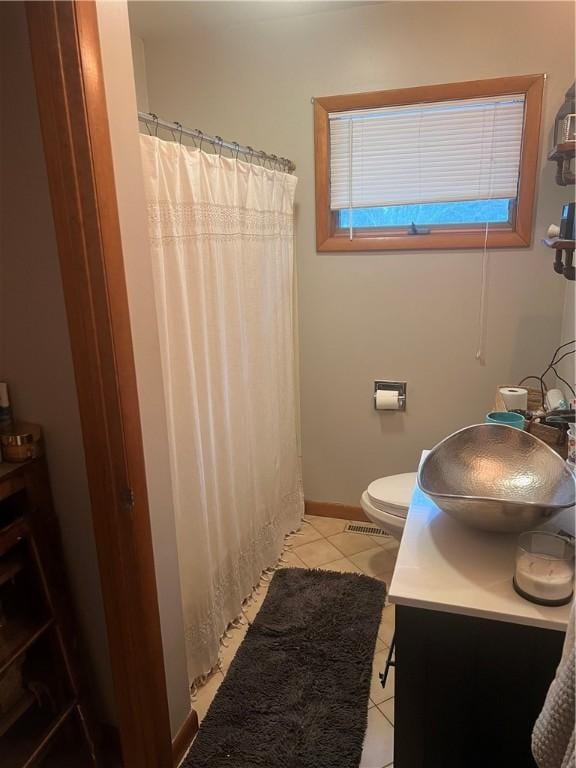 bathroom featuring baseboards, toilet, a shower with curtain, tile patterned floors, and vanity