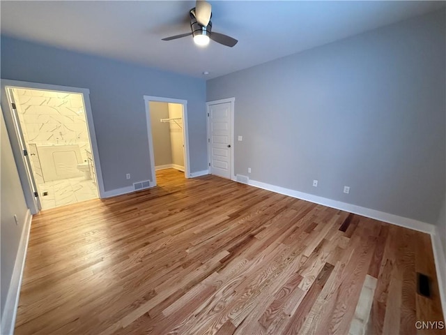 unfurnished bedroom featuring light wood finished floors, visible vents, baseboards, and a closet