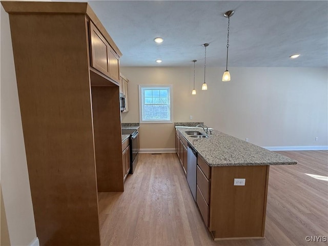 kitchen featuring brown cabinets, light wood-style floors, stainless steel appliances, and decorative light fixtures