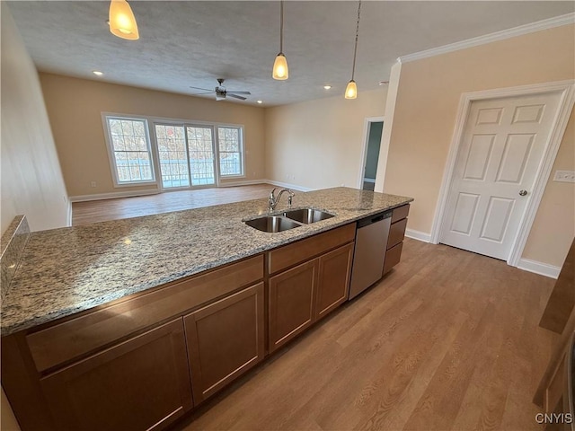 kitchen with dishwasher, hanging light fixtures, light stone counters, and a sink