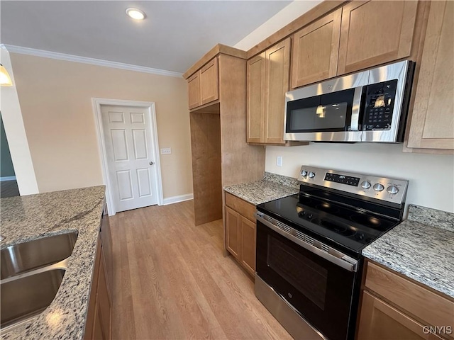 kitchen with light stone counters, light wood-style flooring, appliances with stainless steel finishes, ornamental molding, and a sink